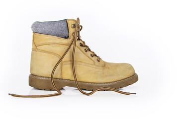 Single  vintage durable yellow leather hiking boot with laces in a worn look. One beige used military shoe with thick sole. Isolated on white background. Studio light. Copy space