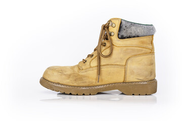 Single  vintage durable yellow leather hiking boot with laces in a worn look. One beige used military shoe with thick sole. Isolated on white background. Studio light. Copy space
