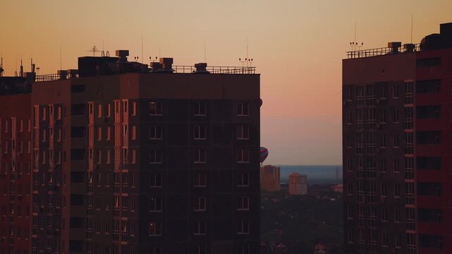 Balloon parade in the city, balloons over the city, balloons flying over the city, balloons at sunset in the city