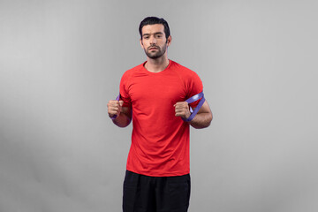 Full body length gaiety shot athletic and sporty young man with fitness elastic resistance band in standing posture on isolated background. Healthy active and body care lifestyle.