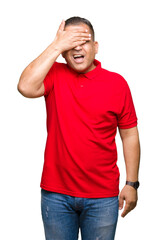 Fototapeta premium Middle age arab man over isolated background smiling and laughing with hand on face covering eyes for surprise. Blind concept.