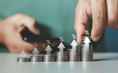 Interest rate and dividend concept. Businessman stacking coins money with up arrow and percentage...