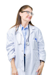 Middle age mature doctor woman wearing medical coat over isolated background looking away to side with smile on face, natural expression. Laughing confident.