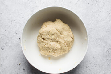 overhead view of dough for making nigerian egg roll in a white ceramic bowl, process of making nigerian egg roll and small chops