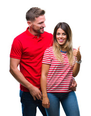 Fototapeta premium Young couple in love over isolated background smiling with happy face looking and pointing to the side with thumb up.