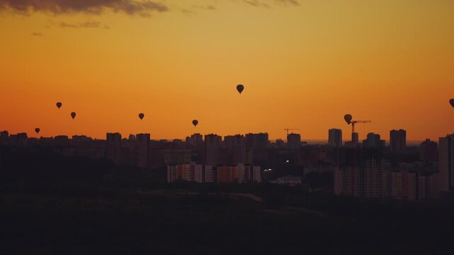 Balloon parade in the city, balloons over the city, balloons flying over the city, balloons at sunset in the city