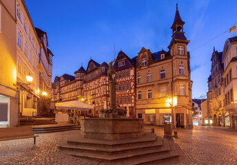 Fototapeta premium Evening view of the fountain and half-timbered buildings on Marburg's Market Square, Germany