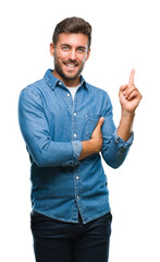 Fototapeta premium Young handsome man over isolated background with a big smile on face, pointing with hand and finger to the side looking at the camera.