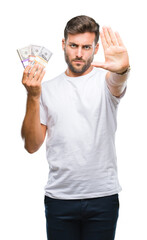 Young handsome man holding stack of dollars over isolated background with open hand doing stop sign...