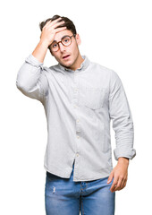 Young handsome man wearing glasses over isolated background surprised with hand on head for mistake, remember error. Forgot, bad memory concept.