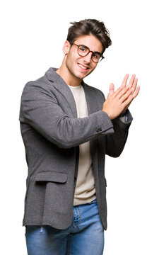 Young business man wearing glasses over isolated background Clapping and applauding happy and joyful, smiling proud hands together