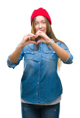 Young caucasian beautiful woman wearing wool cap over isolated background smiling in love showing heart symbol and shape with hands. Romantic concept.