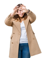 Beautiful plus size young woman wearing winter coat over isolated background Doing heart shape with hand and fingers smiling looking through sign