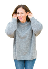 Beautiful middle age woman wearing winter sweater over isolated background Trying to hear both hands on ear gesture, curious for gossip. Hearing problem, deaf