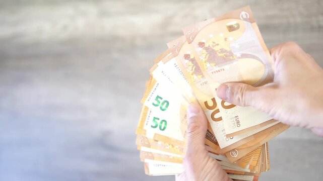 4k video of hands counting European Euro banknotes and throwing them on a table. Concept: euro devaluation, wasting, paying taxes. loans and micro credits easy money.