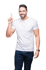 Young man wearing casual white t-shirt over isolated background pointing finger up with successful idea. Exited and happy. Number one.