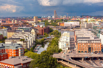 Aerial view of modern buildings and a canal in Stockholm, Sweden, under a cloudy sky