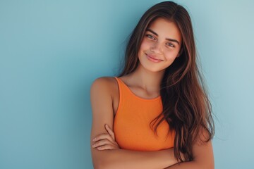 Obraz premium Smiling woman in orange top smiling with arms crossed in orange top happy concept