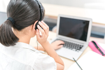 学校でパソコンを使って英会話・英語のリスニングをする子供の後ろ姿(小学生・中学生・高校生)
