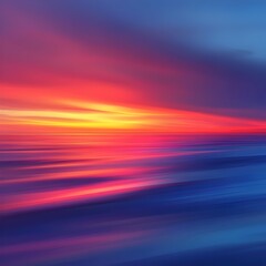 Fototapeta premium A mesmerizing sunset with vibrant orange, pink, and blue tones blending seamlessly over a serene ocean, reflecting the colorful sky in the calm water, evoking tranquility and peace.