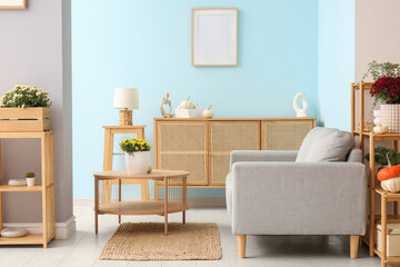 Interior of modern living room with grey sofa and beautiful chrysanthemum flowers on coffee table