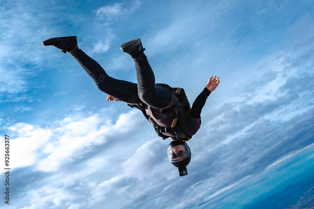 Wall mural woman skydiver falling alone in cloudy landscape