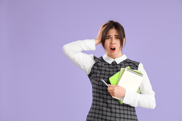 Beautiful young stressed businesswoman with notebooks on purple background. Stress Awareness Month