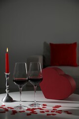 Burning candle, wine in glasses and paper hearts on table indoors