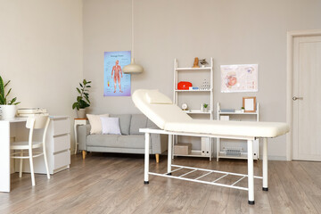 Interior of light medical office with couch, sofa and doctor's workplace