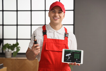 Male worker holding tablet computer with installed alarm system in office