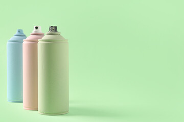 Spray paint cans on green background