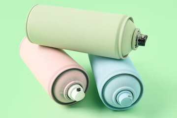 Spray paint cans on green background