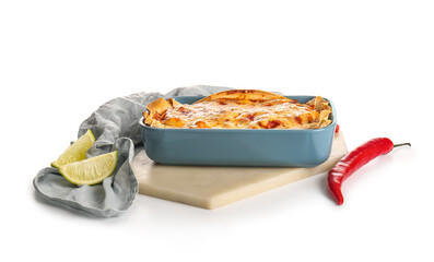 Baking dish with tasty enchilada, chili pepper and lime on white background