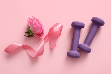 Pink ribbon, dumbbells and flower on color background. Breast cancer awareness concept