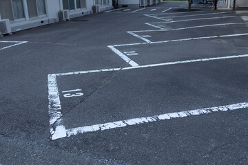 Faded Parking Lot Markings in a Quiet Residential Area: The Numbered Spaces Show Signs of Wear, Reflecting the Passage of Time in an Urban Environment