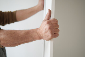 A man is currently holding a door frame while he is engaged in construction work activities