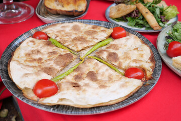 Enjoy a flavorful quesadilla garnished with fresh cherry tomatoes and bright bell peppers