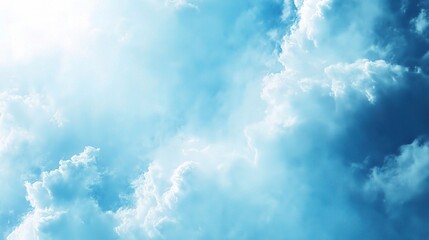 Fototapeta premium Celestial Serenity: A breathtaking view of a vibrant blue sky filled with fluffy white clouds, bathed in the soft glow of sunlight.