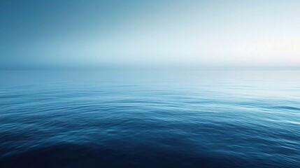 Obraz premium Serene Ocean Horizon: A breathtaking vista of tranquil blue waters stretching towards a misty horizon. The serene stillness evokes a sense of peace and vastness, perfect for meditation, relaxation.