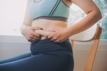 fat woman, fat belly, chubby, obese woman hand holding excessive belly fat with measure tape, woman diet lifestyle concept