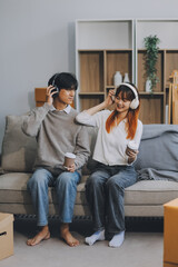 Naklejka premium Asian Female discussing new project with male colleague. Young woman talking with young Asian man with financial on sofa in home office