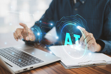 Closeup hand using computer laptop with futuristic digital interface displaying AI technology,...