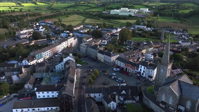 Clones Town, County Monaghan, Ireland, April 2023. Drone orbits clockwise around the Diamond from behind the St Tiarnach's Church of Ireland spire revealing the historic architecture.