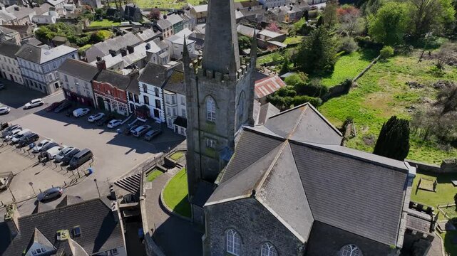 Clones Town, County Monaghan, Ireland, April 2023. Drone orbits clockwise around St Tiarnach's Church of Ireland revealing the facade of the old chapel overlooking the town.