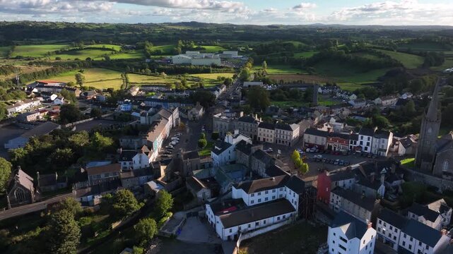 Clones Town, County Monaghan, Ireland, April 2023. Drone orbits clockwise around the Diamond in the center of town in an overview showcasing the old buildings built up on a hill.