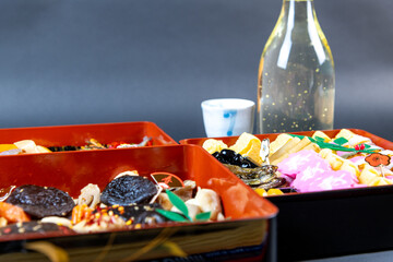 盛り付けられたお節料理と金箔入りの日本酒