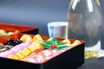 盛り付けられたお節料理と金箔入りの日本酒