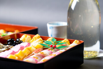 盛り付けられたお節料理と金箔入りの日本酒