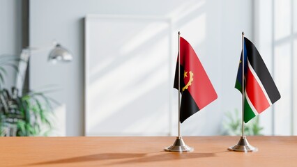 FLAGS OF ANGOLA AND SOUTH SUDAN ON TABLE
