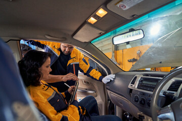 Technician team are working to detect defect of customer car for math program to repair on car garage.